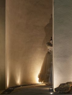 a light shines on the side of a wall next to a vase with flowers in it