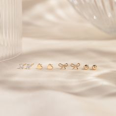 Delight in the dainty sparkle of our Tiny Cubic Zirconia Basket Stud Earrings! These simple earrings may be little, but they pack a big shine. With a dazzling 7a quality cubic zirconia gemstone set in 14k solid gold, this pair is as perfect for special occasions as it is for every day. Shower safe, gentle on sensitive skin, and durable, these earrings bring a bit of sparkle with you wherever you go! DETAILS 14k solid gold studs with 14k butterfly backs 3mm high 7a quality cubic zirconia stones P Love Knot Ring, Diamond Initial Necklace, Solid Gold Bracelet, Tiny Bow, Minimal Earrings, Solid Gold Necklace, Diamond Jewelry Necklace, Solid Gold Earrings, Heart Stud Earrings