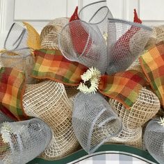 a close up of a wreath with burlocks and flowers on the front door