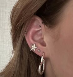 a close up of a person with ear piercings on their ears and one in the shape of a star