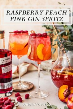 raspberry peach pink gin spritz in two glasses next to a pitcher of wine