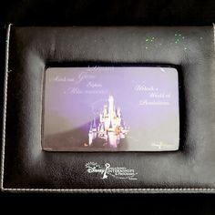 a black leather frame with a disney castle on the front and purple lettering that says, mickey mouse's magic kingdom