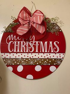 a red and white christmas ornament hanging on a wall