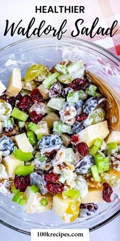 a glass bowl filled with fruit salad next to a red and white checkered table cloth