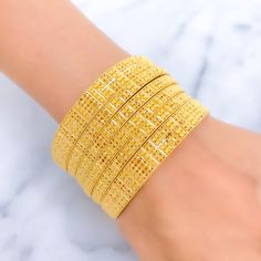 Indulge in luxury with our Royal Floral Checkered 22K Gold Bangle Set. Crafted in 22k gold, this exquisite set features a total weight of 92.5g, radiating opulence. The captivating floral checkered design and lustrous yellow gold finish make it a statement of high fashion. Bangle Size 2.7 with a 2.45" diameter opening. Set includes 6 stunning bangles PRODUCT DETAILS Gold Purity(karat): 22k Gold Weight(grams): 92.5 Item Finish: Yellow Gold Bangle Size: 2.7 Bangle Opening(diameter): 2.45" Number O Yellow Gold-plated Bangle Bracelet, Yellow Gold-plated Bangle Jewelry, Yellow 22k Gold Bangle With Intricate Design, Yellow 22k Gold Bracelet For Festive Occasions, Yellow 22k Gold Festive Bracelet, Festive 22k Gold Yellow Bracelets, Traditional Yellow Bracelets For Formal Occasion, Festive Yellow 22k Gold Bracelet, Yellow Gold-plated Bangle As Gift