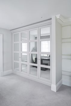 an empty room with white walls and glass doors