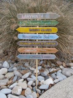 a wooden sign sitting on top of a pile of rocks