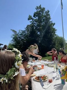 a group of people sitting around a table eating food