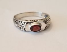 New Hand crafted Sterling silver ring with genuine oval garnet gemstone. Ring is marked with "925" to signify metal purity. Band measures 2.5 mm at it's narrowest and 6 mm at it's widest. Gemstone measures 7 mm x 5 mm. Ring is available in sizes 6,7, 8, 9 or 10. Ring comes in a gift box. January birthstone. The Garnet gemstone is associated with love and friendship. With associations with the heart, blood, inner fire, and life force, garnets have long been considered symbols of love. Garnet symbolism also extends to friendship. Garnet is also associated with health, helping flush out body toxins and keep circulation strong. It's a stone that wants to keep your blood flowing, your heart beating, and your metabolism working to the best of its ability. Body Toxins, January Birthstone, Life Force, Garnet Gemstone, Sterling Silver Bands, Love Symbols, Red Garnet, Gemstone Ring, Solitaire Ring