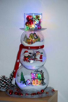 three snow globes are stacked on top of each other and decorated with christmas lights