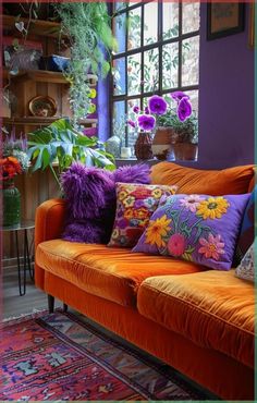 a living room filled with lots of colorful furniture and flowers in the window sill