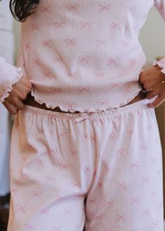 Tap into the ultimate coquette girl aesthetic with our pointelle pajama sets. Our Pointelle Pants are designed in soft 100% cotton fabric with our new bow print, coming in light pink/pink and white/light blue. Extremely soft and lightweight, this buttery pointelle fabric provides subtle stretch for the perfect true to size fit. Pair with matching tank top or love sleeve for the cutest set! Long pants with covered elastic waist & baby bow detail Light pink body with pink bow print White body with Pointelle Pajama Set, Pink Cute Clothes, Cute Stuff Aesthetic, Soft Pink Outfits, Cute Fabric Prints, Fancy Pjs, Pajama Set Aesthetic, Coquette Pjs, Pointelle Pants