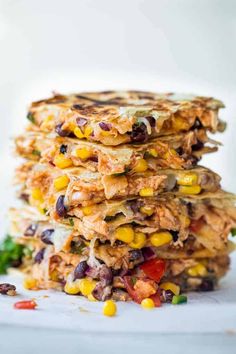 three quesadillas stacked on top of each other with corn and black beans