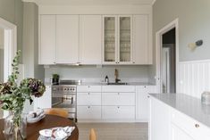 the kitchen is clean and ready to be used for cooking or dining room furniture, as well as flowers in vases on the table