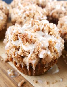 a muffin with white icing sitting on top of a wooden cutting board