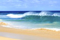 the ocean is blue and green with waves coming in from the shore on a sunny day