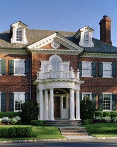 a large red brick house with white columns