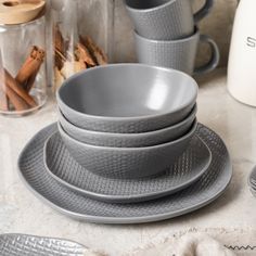 a stack of gray dishes sitting on top of a counter