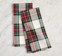 two plaid napkins sitting on top of a marble countertop next to each other