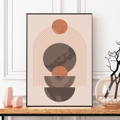 an art print on a shelf next to a vase with rocks and branches in it