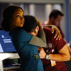 two people hugging each other in front of a computer screen with blood all over them