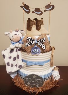 a three tiered cake decorated with cow hats and other items on top of it