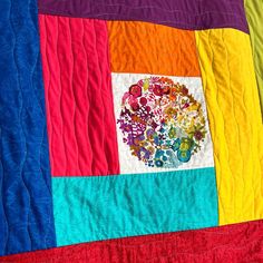 a multicolored quilt with an image of flowers on it