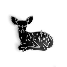 a black and white deer pin with stars on it's back, sitting down