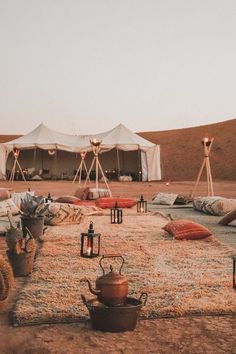 an outdoor area with several tents and teapots on the ground in front of them