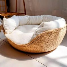 a wicker dog bed on the floor next to a black and white cat toy