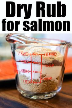 a measuring cup filled with food on top of a wooden table