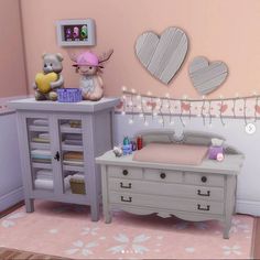 a baby's room is decorated in pastel pinks and greys with hearts on the wall