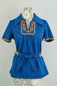 "This blouse is adorable. Pair it with shorts or jeans. Blue knit fabric with yellow sun embroidered accents. Hemp/Burlap detail and self-tie belt. Fits like a medium, but check measurements below for a good fit. ✂------✂------✂------✂------✂ Measurements: Bust - 36\" Waist - 36\" Length - 27\" ✂------✂------✂------✂------✂ If you have questions, please feel free to convo me. ♥ 86 Charlotte Street - The Way We Were Vintage Boutique ♥ ✩facebook.com/thewaywewere2 ✩twitter.com/thewaywewere2 ✩instagram.com/thewaywere2 All photos property of The Way We Were / 86 Charlotte Street. Do not use without explicit written permission from the owner." Charlotte Street, Black And White Coat, Checkered Blouse, Mexican Fashion, Mexican Blouse, 60s Retro, Blue Knit Sweater, Retro Tops, Yellow Sun