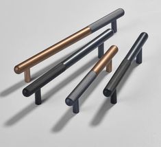 three different types of metal handles on a white surface