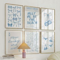 three blue and white posters on the wall above a bed with a lamp next to it