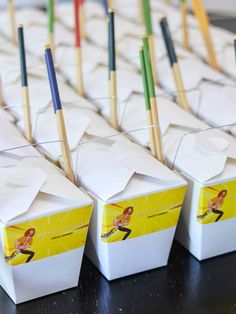 several boxes with toothbrushes sticking out of them sitting on a black table top