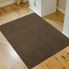 a brown rug is on the wooden floor