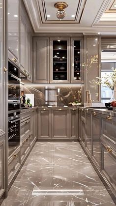 a very nice looking kitchen with metallic cabinets and marble flooring in the middle of it