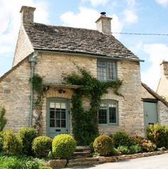 an old stone house with ivy growing on it's roof