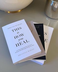 three books sitting on top of a white table