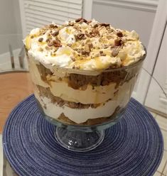 a layered dessert is sitting on top of a blue place mat in front of a glass table