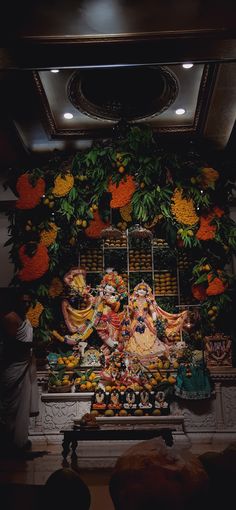 an idol in the middle of a room filled with flowers and other decorations on display