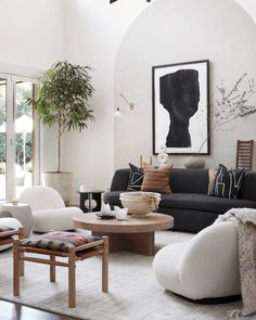 a living room filled with furniture and a painting on the wall above it's windows