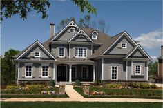 a large gray house with lots of windows on the front and side of it's roof