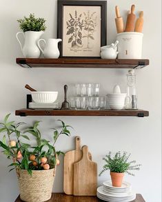 two wooden shelves filled with dishes and plants