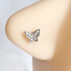 a pair of diamond butterfly earrings on a mannequin's back side view