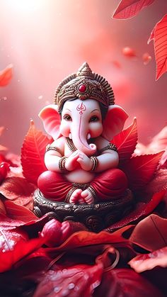 an elephant statue sitting on top of a pile of leaves and red flowers in the background