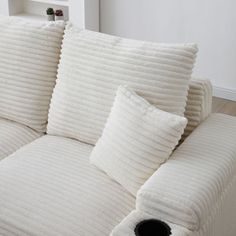 a white couch with several pillows on it