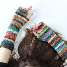 a woman with her hair in the air wearing knitted fingerless mittens and gloves