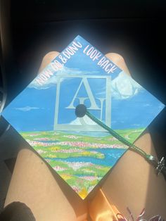 someone is holding up a colorful graduation cap